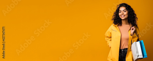 Woman with shopping bags; yellow background with empty space 