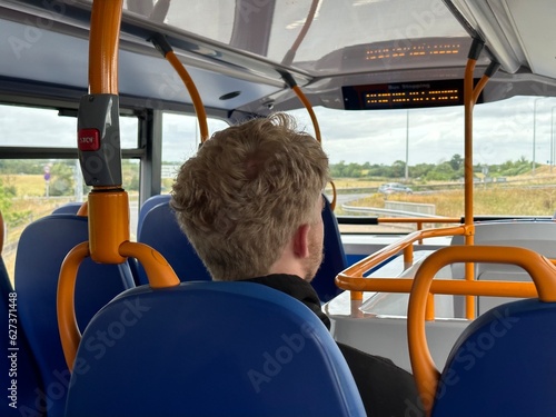 Rear view shot of a man sitting in a public transport bus