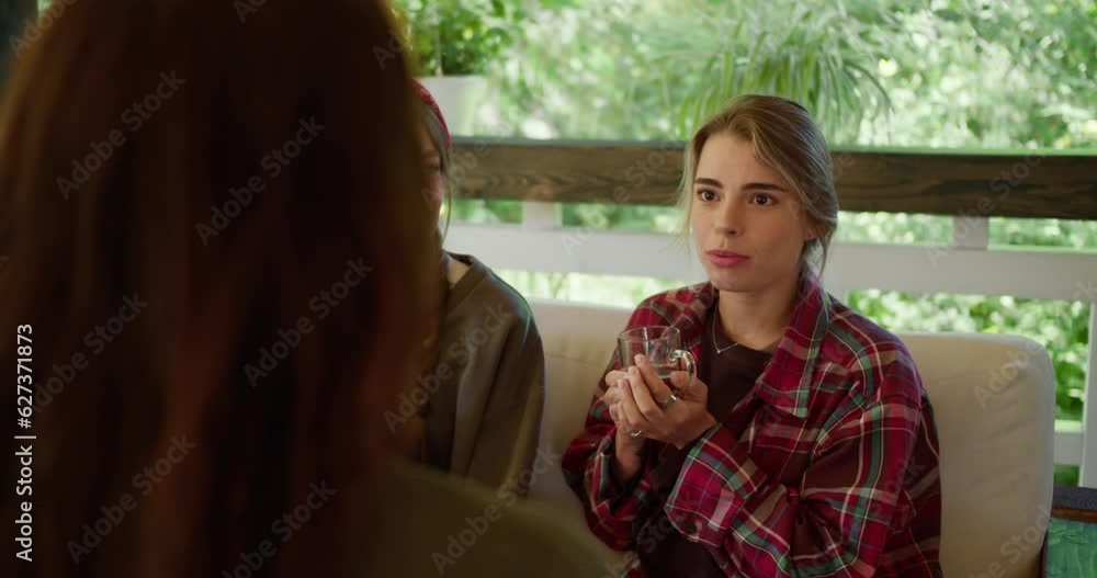 First-person view of a brunette girl chatting with two girls, they are sitting in a gazebo in nature and drinking tea. Blonde girl in a red plaid shirt and a girl in a green t-shirt First-person view of a brunette girl chatting with two girls, they are sitting in a gazebo in nature and drinking tea. Blonde girl in a red plaid shirt and a girl in a green t-shirt
