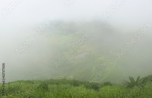 Panoramic landscape view of beautiful lush scenic Sahyadri mountains through dense fog. The view is as seen from Sinhagad in Pune, Maharashtra, India photo