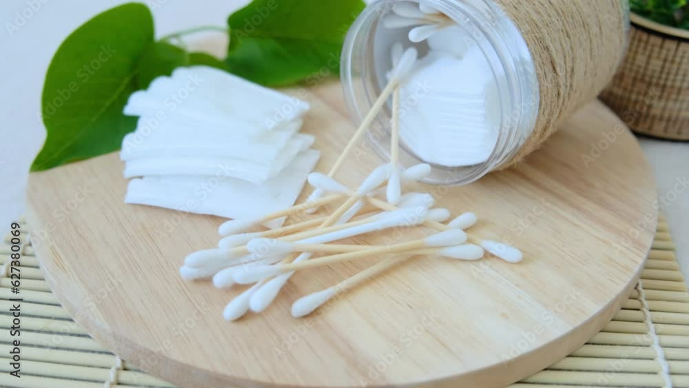 Close-up of cotton pads and cotton buds taken from a jar. Close-up of cotton pads and cotton buds taken from a jar.