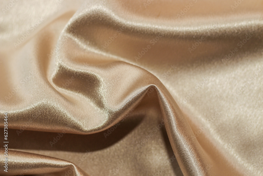 Golden shiny texture of silk satin satin with folds. Golden shiny texture of silk satin satin with folds.