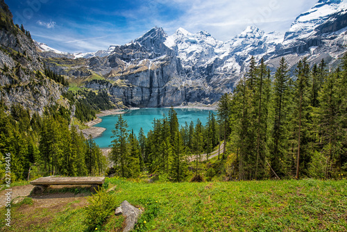 Amazing tourquise Oeschinnensee with waterfalls, wooden chalet and Swiss Alps, Berner Oberland, Switzerland. photo