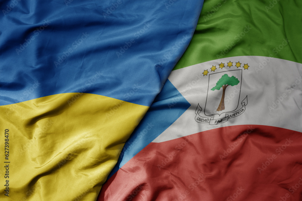 big waving national colorful flag of ukraine and national flag of equatorial guinea .