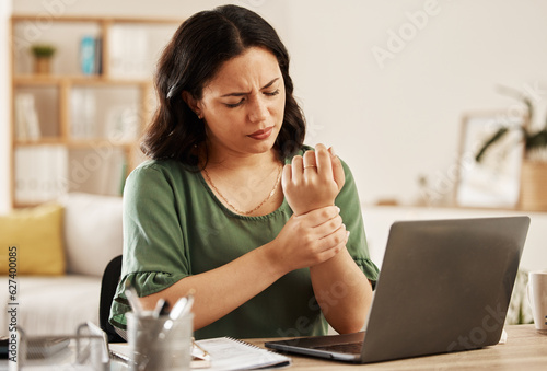 Remote work from home, laptop and woman with wrist pain, injury and overworked by desk. Female person, entrepreneur or freelancer with a pc, carpal tunnel syndrome and ache with sprain hand and joint photo