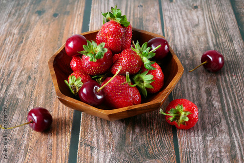 Fresh tasty strawberry and cherry on wooden background. Fresh organic berries macro. Fruit background