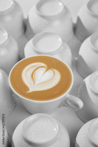 Bright photo for coffeeshop stories advertising. Logo heart on alone coffee latte or cappuccino in white cup background  top view