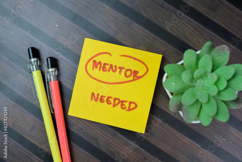 Concept of Mentor Needed write on sticky notes isolated on Wooden Table.