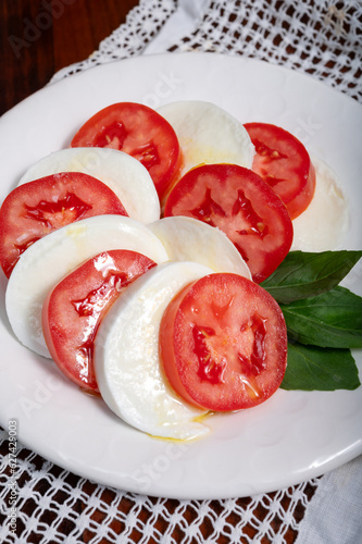 Itaian vegetarian food, fresh caprese salad made with white soft italian mozzarella cheese, red tomato and green basil with olive oil