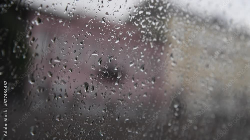Abstract rainy background. Few raindrops runs down car or turboat window. Dark blurred city buildings in the background. Soft focus. Real time video. Bad weather forecast theme. Abstract rainy background. Few raindrops runs down car or turboat window. Dark blurred city buildings in the background. Soft focus. Real time video. Bad weather forecast theme.