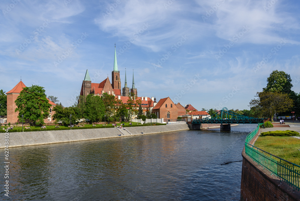 Outdoor view on the waterside of Oder river and background of Archbishop's Palace, Collegiate Church of the Holy Cross and St. Bartholomew and Wieża Katedry św. Jana Chrzciciela in Wroclaw, Poland.