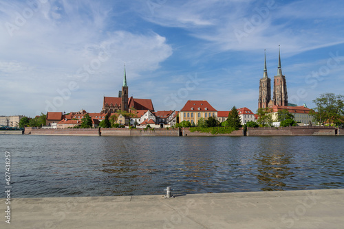 Outdoor view on the waterside of Oder river and background of Archbishop's Palace, Collegiate Church of the Holy Cross and St. Bartholomew and Wieża Katedry św. Jana Chrzciciela in Wroclaw, Poland.