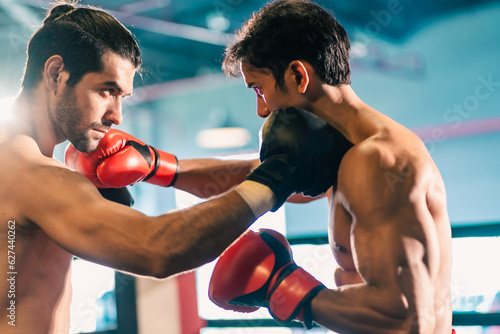 MMA or Thai Boxing match, Two professional fighters punching or boxing, Fit muscular caucasian athletes or boxers fighting, Sport competition and human emotions, Gym atmosphere background © chokniti