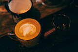 vintage tone of some people pour milk to making latte art coffee at cafe or coffee shop, barista making latte art, shot focus in cup of milk and coffee, vintage filter image