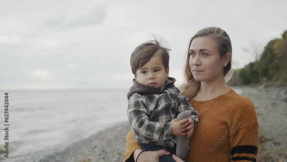 A young mother walks with her son on the shores of the picturesque Lake Ontario A young mother walks with her son on the shores of the picturesque Lake Ontario