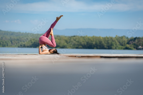Fitness Asian woman doing yoga in park, Young woman practicing yoga, female happiness in landscape background, Lifestyle of exercise and pose for relax healthy life in the morning nature outdoor