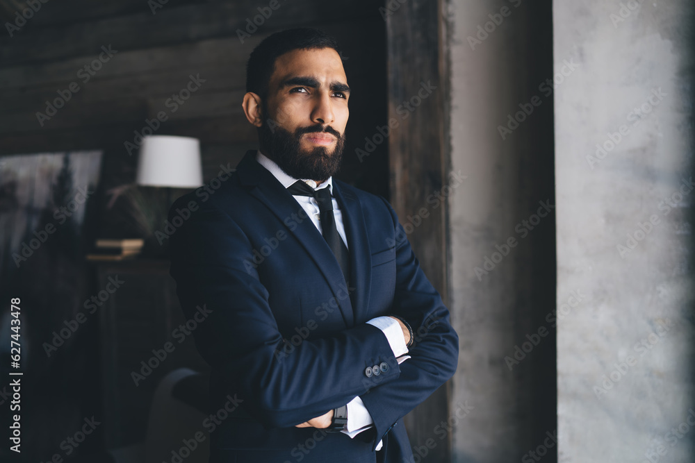 Serious ethnic man with arms crossed looking away Serious ethnic man with arms crossed looking away