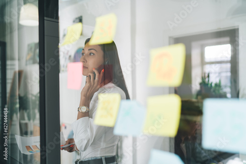 Serious businesswoman talking on smartphone in office