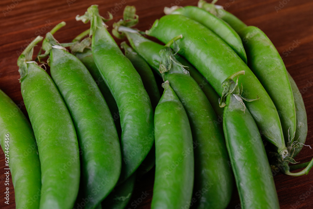 Green pea pods on wooden table. Ripe pea.