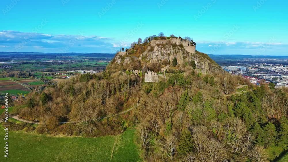 Aerial view of a hill with the ruins of the Hohentwil castle on its top against a blue sky Aerial view of a hill with the ruins of the Hohentwil castle on its top against a blue sky