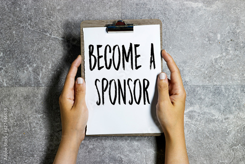 Canvas Print woman hand holding a clipboard with become a sponsor text