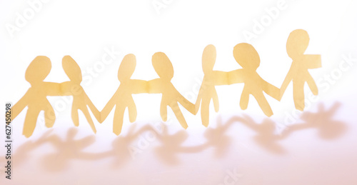 Team of paper chain people united together holding hands teamwork partnership