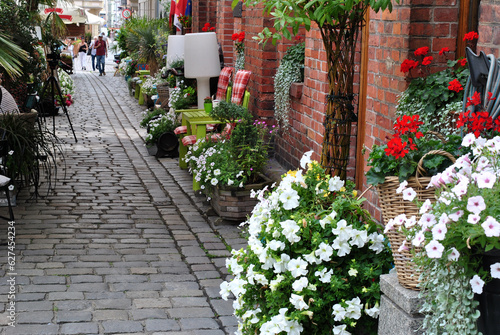 zdjęcie kamiennej ulicy udekorowanej kolorowymi kwiatami