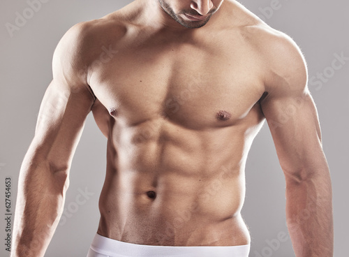 Sexy man, underwear model and muscle with strong chest, abs and body with wellness in studio. Bodybuilder, exercise and healthy male person with gray background and muscles from fitness and workout