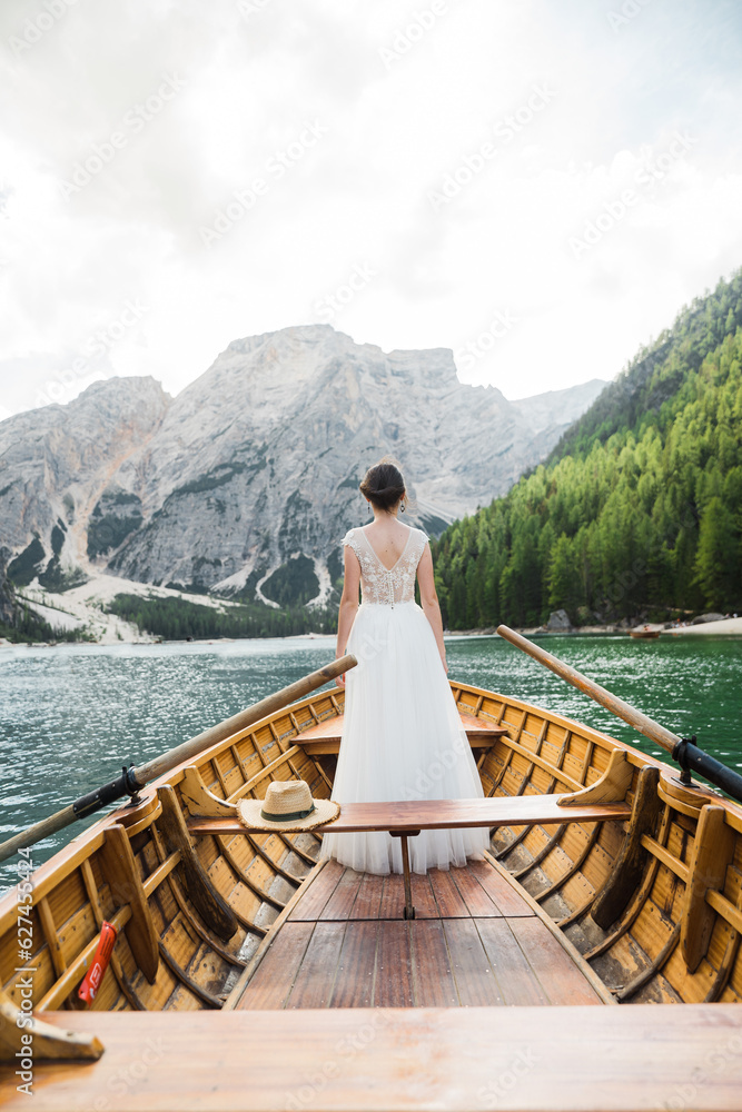 Beautiful female model in her white wedding dress at Lago di Braies