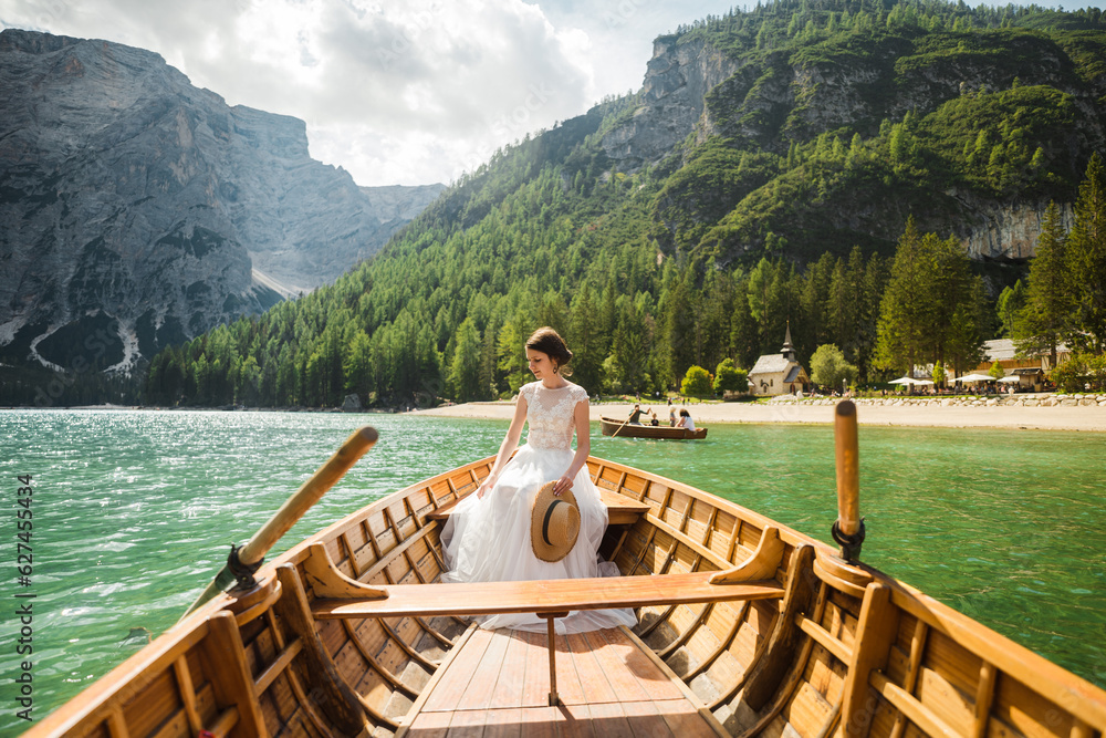 Beautiful female model in her white wedding dress at Lago di Braies