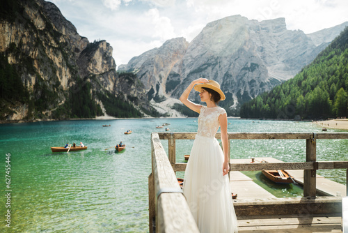 Beautiful female model in her white wedding dress at Lago di Braies