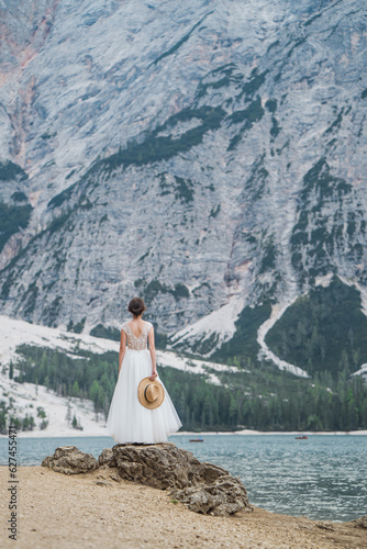 Beautiful female model in her white wedding dress at Lago di Braies