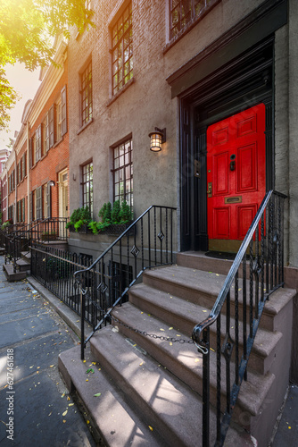 a row of brownstone buildings and stoops in an iconic neighborhood of Manhattan, New York City.