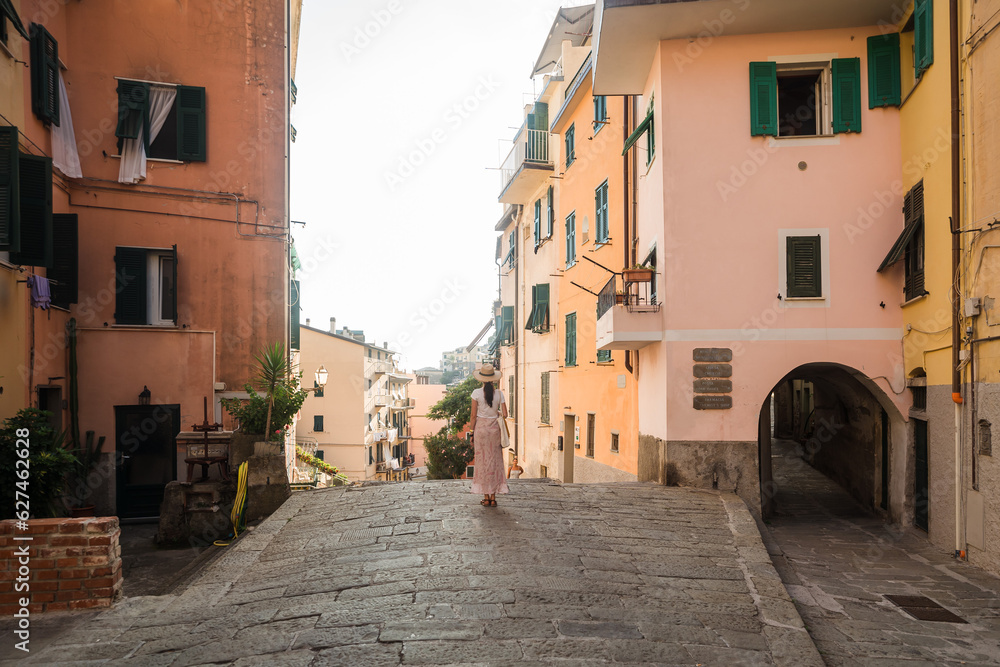 Beautiful female model in front he of the colorful city of Riomaggiore, Cinque Terre, Italy