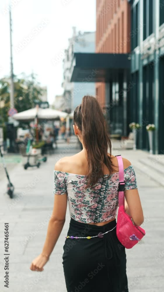 The camera captures the back of a young and attractive girl rushing through the city streets. The camera captures the back of a young and attractive girl rushing through the city streets.