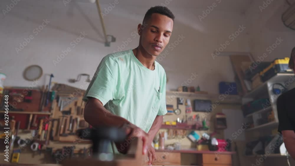 Young woodworking apprentice working at carpentry workshop, close-up hand twisting knob. Job profession workplace concept Young woodworking apprentice working at carpentry workshop, close-up hand twisting knob. Job profession workplace concept