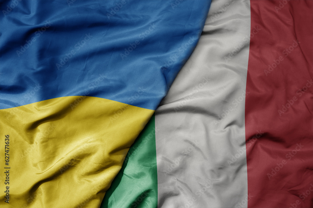 big waving national colorful flag of ukraine and national flag of italy . big waving national colorful flag of ukraine and national flag of italy .