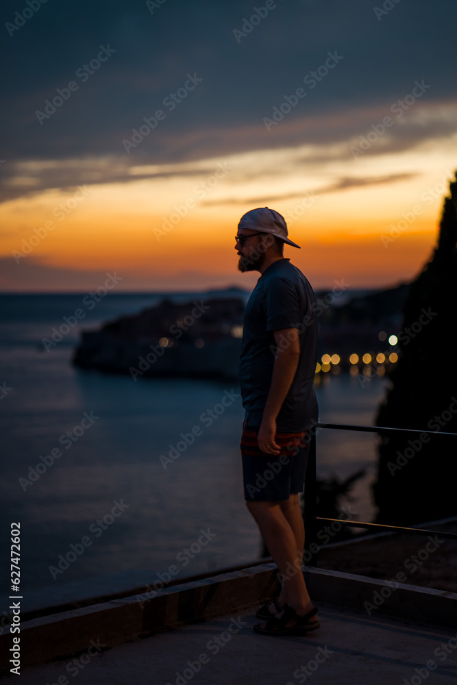 Fototapeta premium Beautiful male model on the streets of Dubrovnik. Amzing golden sunset.