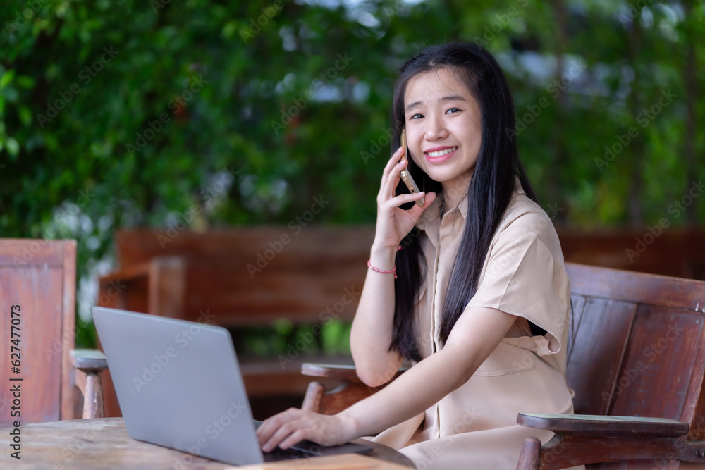 Happy of Young asian teen girl college student talking making using smartphone casual using laptop computer.Online education, elearning concept,freelance people businessfemale Happy of Young asian teen girl college student talking making using smartphone casual using laptop computer.Online education, elearning concept,freelance people businessfemale