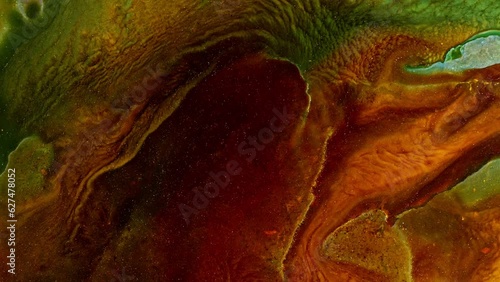 Abstract video of brown colors and greens, in the style of saturated pigment and organic formations. Fluid art with naturalistic landscape background. Liquid formation with swirling acrylics paints. photo