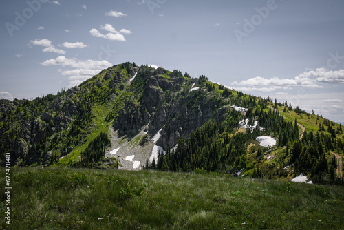 Bilde på lerret Beautiful landscape view of rocky jagged mountain with green grassy meadows and