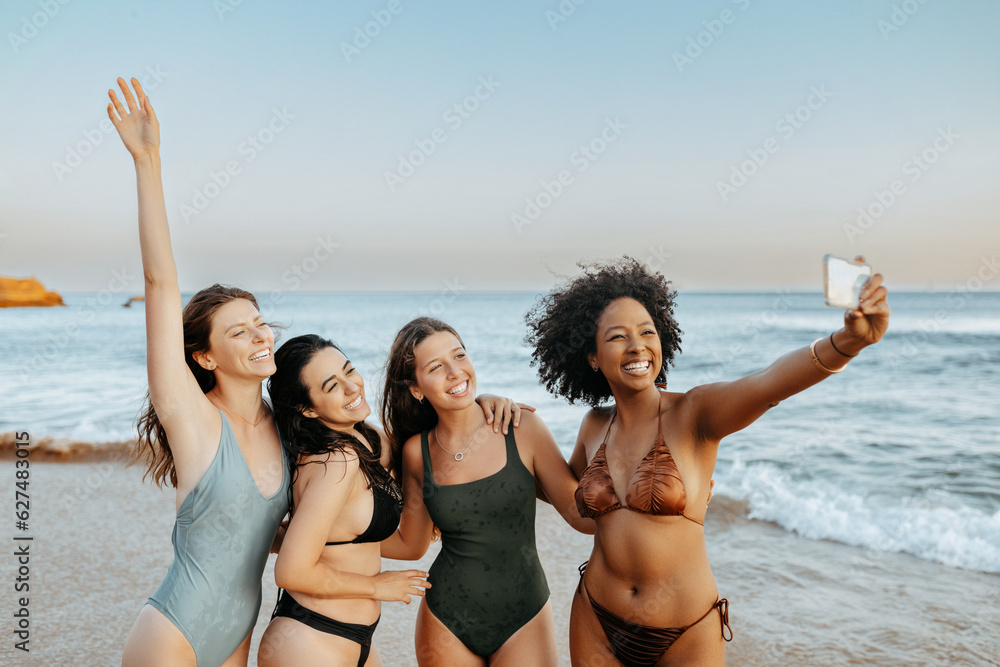 © Prostock-studio - Excited carefree multiracial ladies friends capturing moments spending time together at the beach