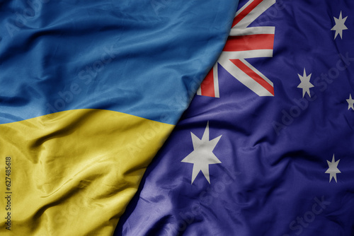 big waving national colorful flag of ukraine and national flag of australia .