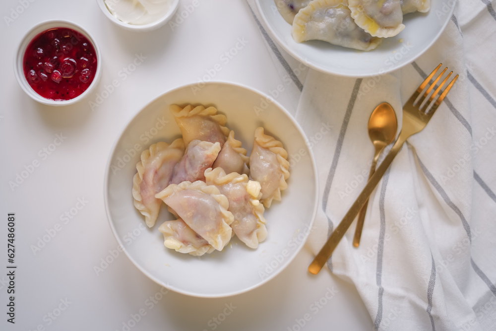 Fresh cooked varenyki with cherry in white bowl top view. Traditional Ukrainian food Fresh cooked varenyki with cherry in white bowl top view. Traditional Ukrainian food