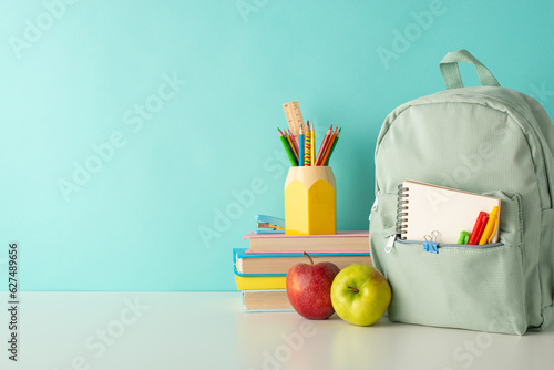 Enliven the classroom atmosphere with side-view image of cheerful school supplies, penholder, books and rucksack on white desk on blue isolated background, offering space for text or advert inclusion