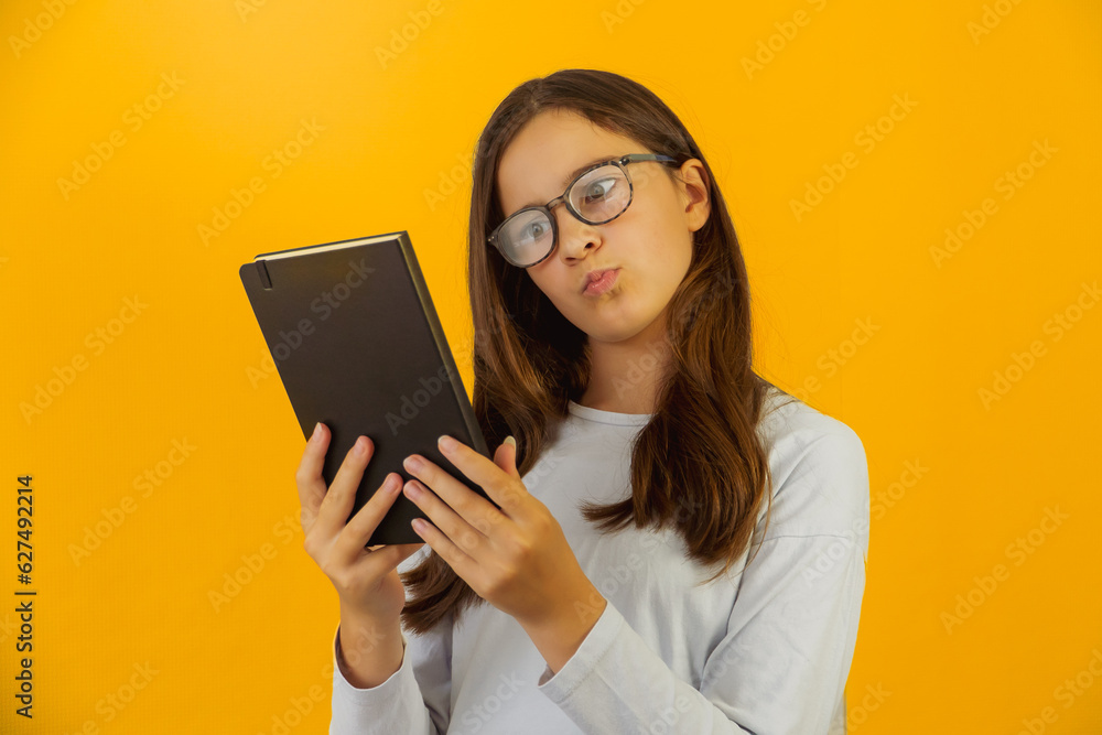 Little lovely girl in glasses holds notepad book in her hands Little lovely girl in glasses holds notepad book in her hands