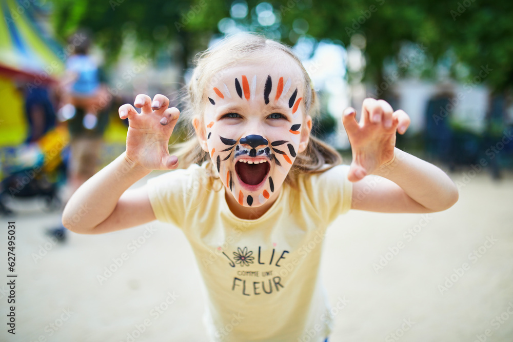 © Ekaterina Pokrovsky - Little preschooler girl with tiger face painting outdoors