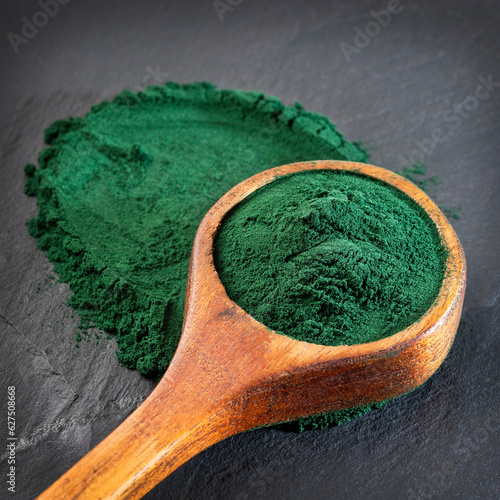 Organic spirulina powder in the wooden spoon - Healthy food