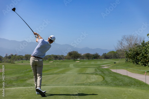 professional golf player hitting the ball. backswing