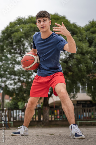 One caucasian teenager stand on basketball court with ball © Miljan Živković